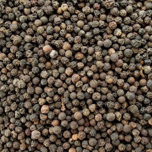 Gros plan sur les grains de poivre de Penja — texture dense et arômes incomparables